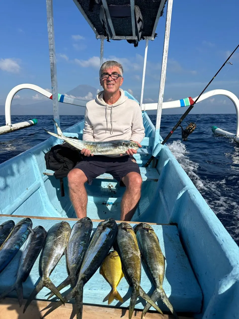 Smiling fisherman giving shaka signs on a boat full of mahi-mahi in Amed