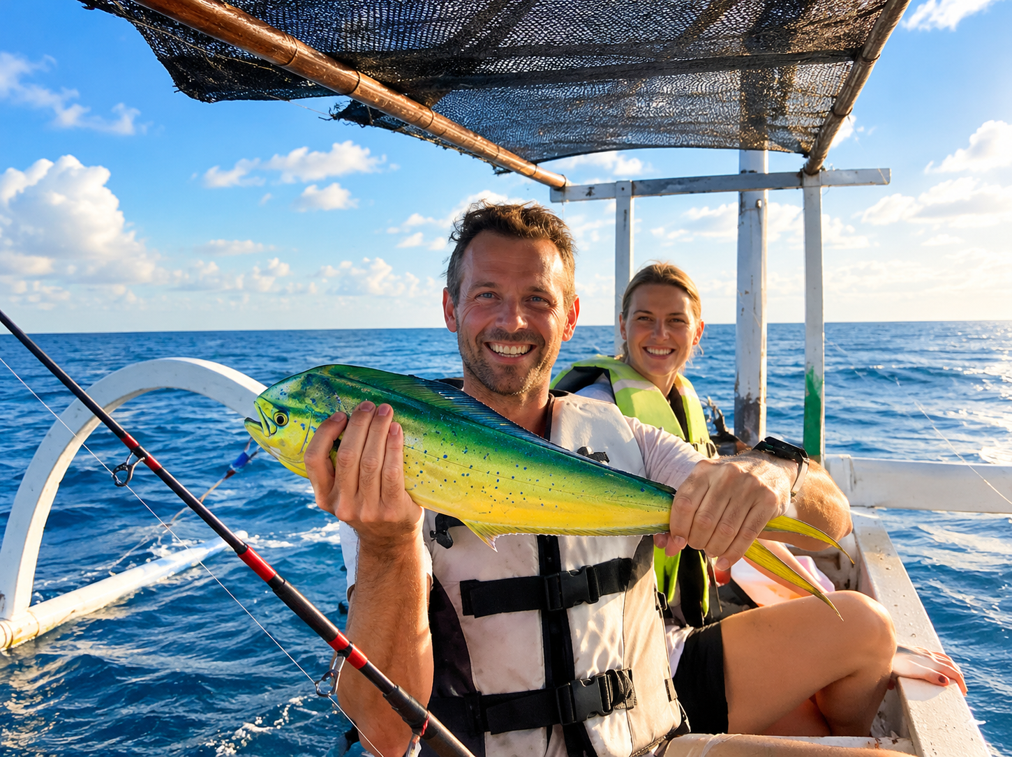 Happy guests on a traditional boat showing their fresh catch in Amed