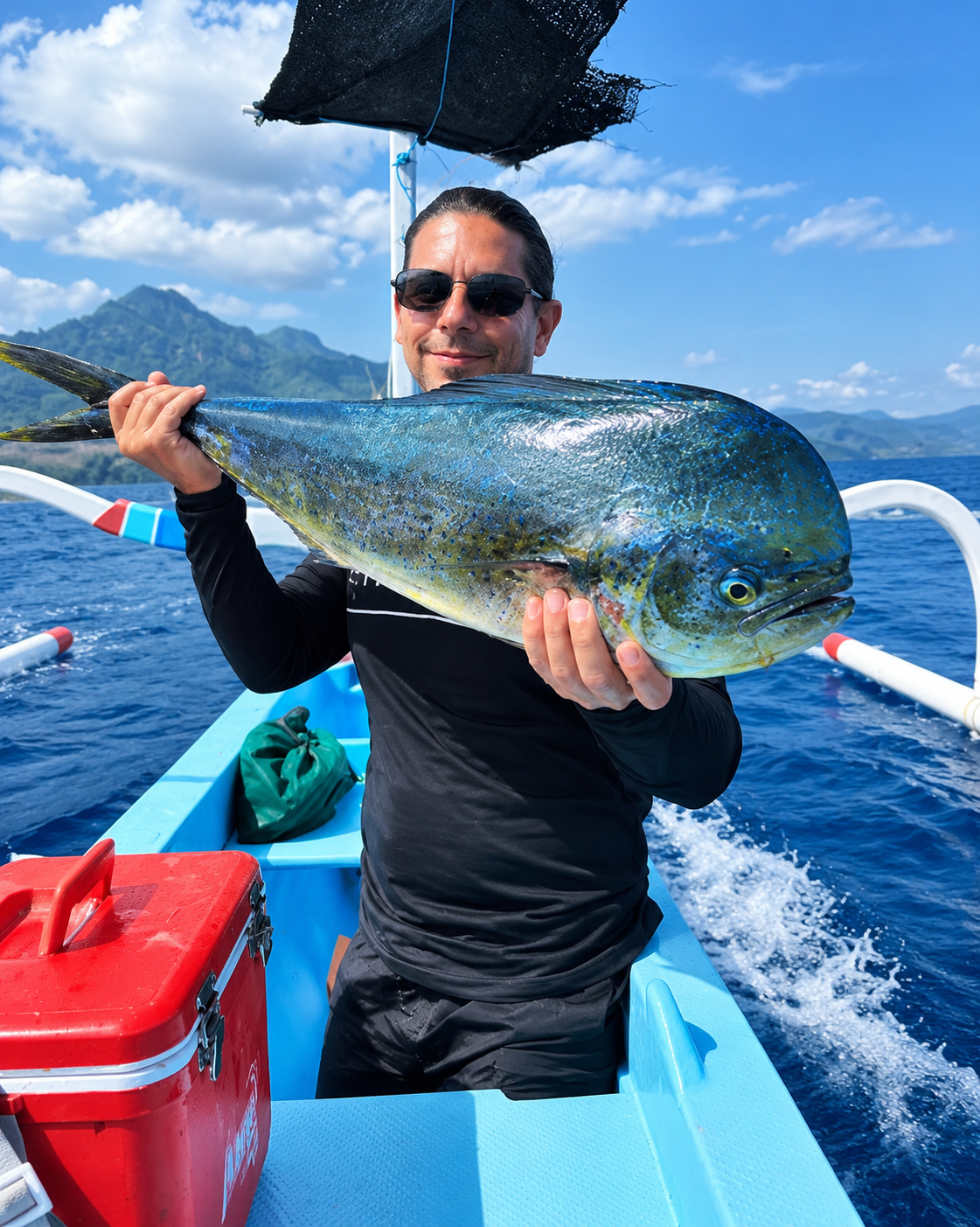 Guest holding a mahi-mahi caught on a fishing trip from Amed, Bali